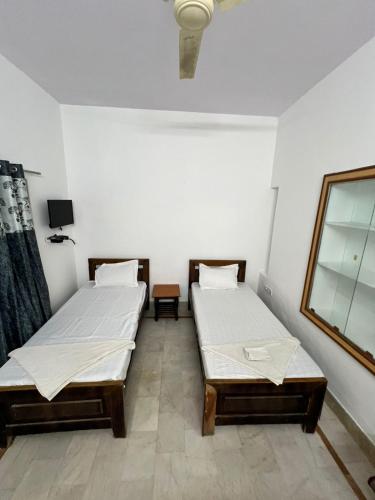 two twin beds in a room with white walls at Golden villa in Jaisalmer