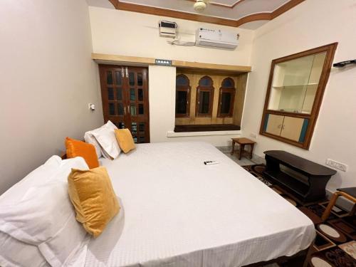 a bedroom with a large white bed with yellow pillows at Golden villa in Jaisalmer