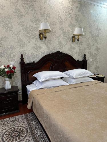 a bedroom with two beds and two lamps on the wall at Lion Hotel in Astana