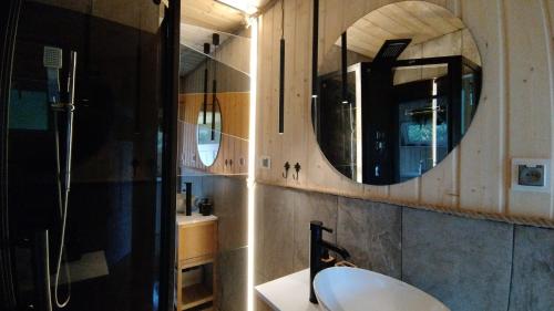 a bathroom with a sink and a mirror at KOCIEWSKA DACZA - domek o podwyższonym standardzie, POMORSKIE, RZEKA, LASY, ŁĄKI in Pogódki