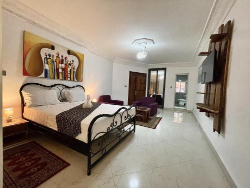 a bedroom with a bed and a tv in it at Touraco Suite Hôtel Business in Mbour