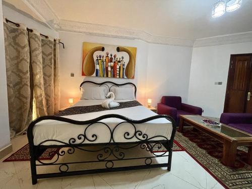 a bedroom with a black and white bed in a room at Touraco Suite Hôtel Business in Mbour