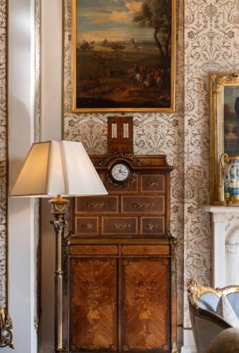 a lamp in a room with a clock on a wall at Cabra Castle Hotel in Kingscourt