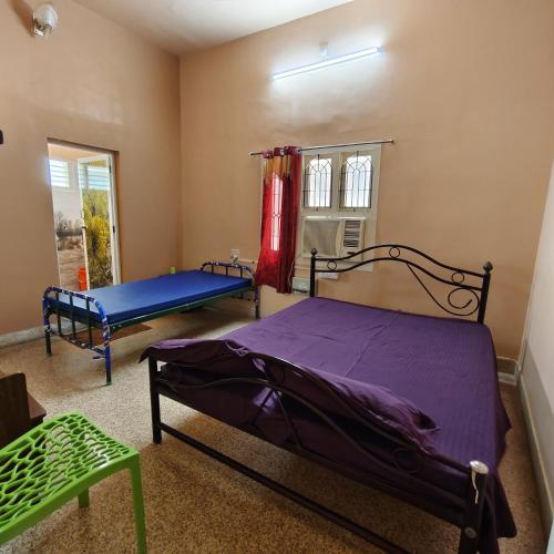 a bedroom with a bed and a window at Square & Dormitory Stays in Tirunelveli