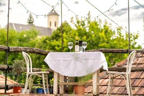 a table with two glasses and a bottle of wine at Márai vendégház in Kács