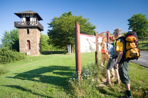 a group of people with backpacks walking towards a lighthouse at BSW Ferienhotel Lindenbach in Bad Ems