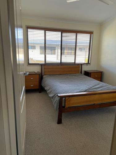 a bedroom with a bed and a large window at Watson in Pialba