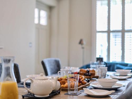 a table with food and cups and plates on it at Elegant Central Guildford Home with Castle Views Pass The Keys in Guildford