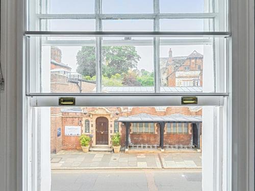 an open window looking out at a brick building at Elegant Central Guildford Home with Castle Views Pass The Keys in Guildford