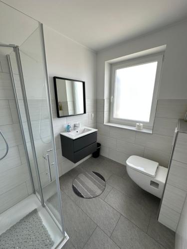 Un baño con inodoro, lavabo y ducha. en Star Ferien Appartement, en Otterndorf