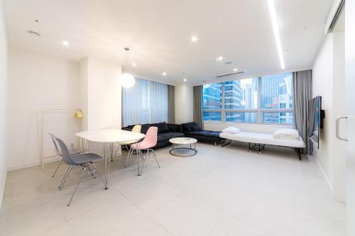 a living room with a couch and a table and chairs at Hotel Modak Namdaemun in Seoul