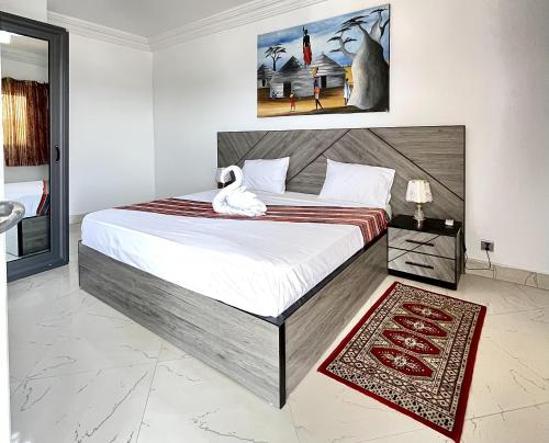 a bedroom with a large bed with a towel on it at Touraco Suite Hôtel Business in Mbour