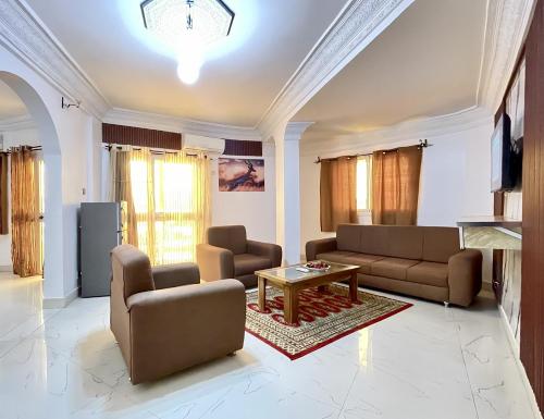 a living room with two couches and a table at Touraco Suite Hôtel Business in Mbour
