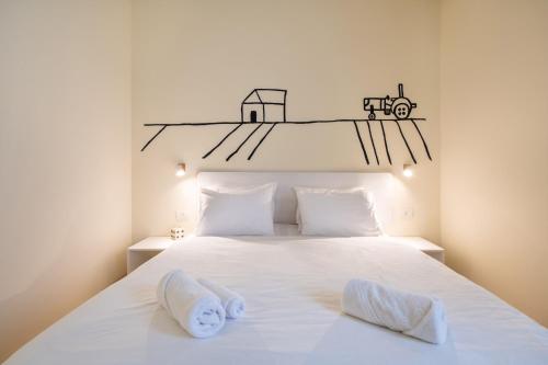 a bedroom with a white bed with two towels on it at Kibbutz Kfar Masaryk Country Lodging in Kefar-Massariq