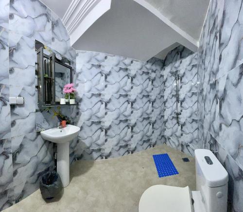 a bathroom with a white sink and a toilet at Touraco Suite Hôtel Business in Mbour