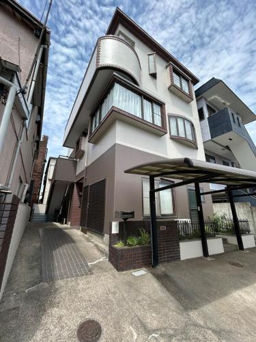 a large building with a large umbrella in front of it at T'S House Numazu in Numazu