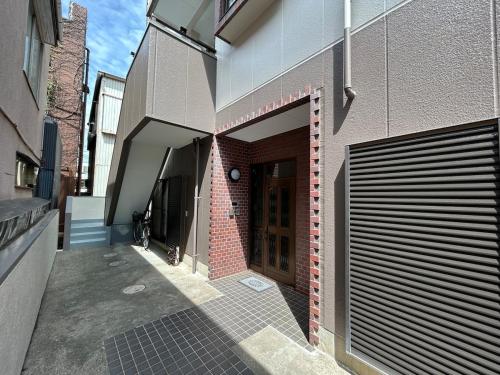 a hallway of a building with a wooden door at T'S House Numazu in Numazu