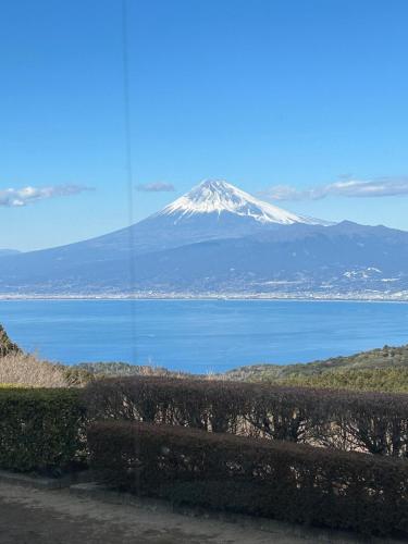 a view of a snow covered mountain over a body of water at T'S House Numazu in Numazu