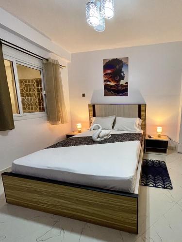 a bedroom with a large bed in a room at Touraco Suite Hôtel Business in Mbour