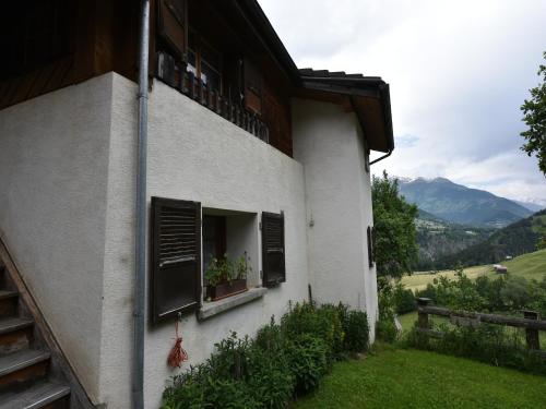 a white building with a window with plants in it at Cozy Stay near Aletsch in Grengiols