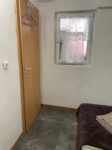a room with a door and a window and a bed at Pension-Einfach Übernacht in Rüdesheim am Rhein in Rüdesheim am Rhein