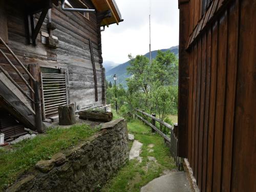 an outside view of an old building next to a wall at Cozy Stay near Aletsch in Grengiols