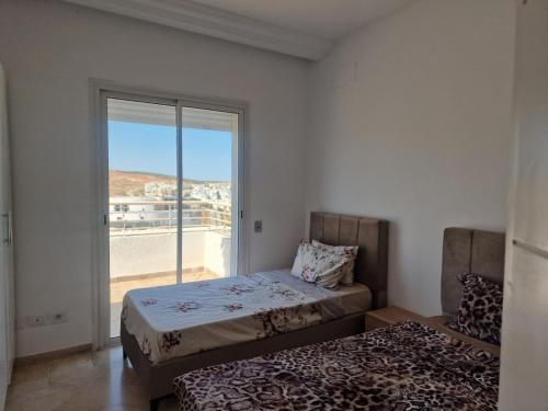 a bedroom with a bed and a window with a view at Appartement terrasse Ennasr in Ariana