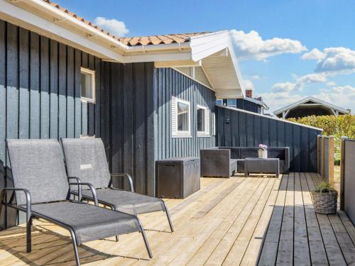 a patio with two chairs on a wooden deck at 4 star holiday home in Lemvig in Lemvig