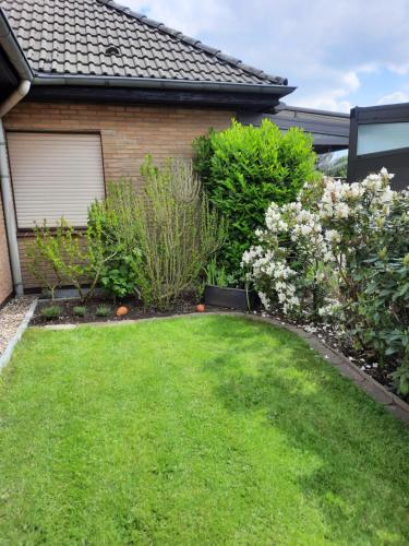 a yard with flowers and a house at Ferienwohnung Höhendorf 5-Sterne-DTV in Ennepetal