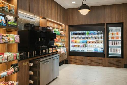 a grocery store aisle with a large refrigerator and a tv at Sheraton Music City Nashville Airport in Nashville