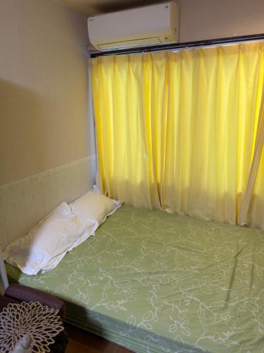 a small bed in a room with a window at 童童民宿 in Tokyo