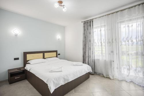 a bedroom with a bed and a large window at Vila de pe deal Poiana stampei in Poiana Stampei