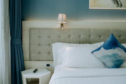 a bedroom with a white bed with a blue pillow at BlueSotel Krabi AoNang Beach in Ao Nang Beach