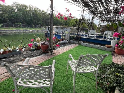 a patio with two chairs and a grass yard at 夏日禾風庭園包棟 in Checheng