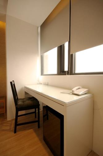 a room with a desk with a chair and a mirror at Mini West Hotel in Taichung