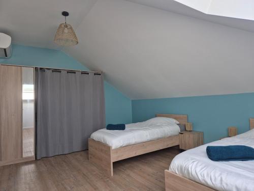 two beds in a room with blue walls at La bulle colorée in Saint-Aubin-lès-Elbeuf