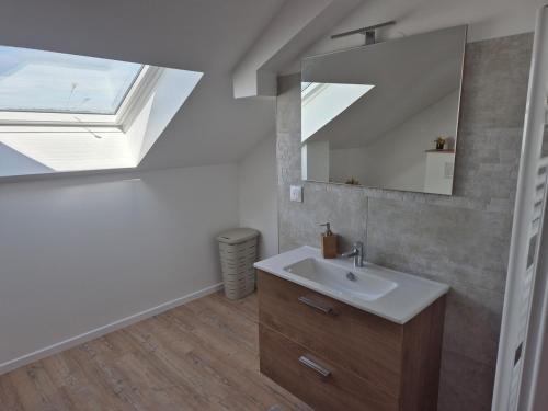 a bathroom with a sink and a skylight at La bulle colorée in Saint-Aubin-lès-Elbeuf