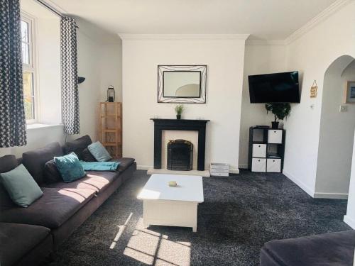 a living room with a couch and a fireplace at Seawards 2 bedroomed Seafront Filey in Filey
