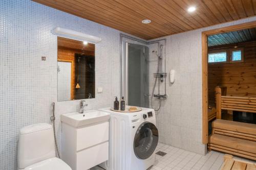Un baño con lavadora y un inodoro. en Villa Sinirinta, Ounasvaara, en Rovaniemi