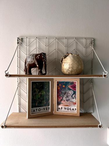 a shelf with two pictures and a statue on it at Ti Lakaz Kreol 2 in Pereybere