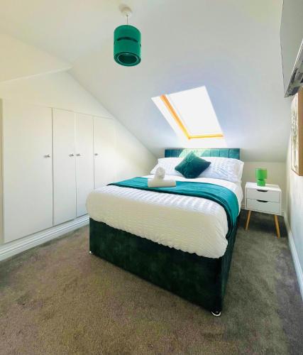 a bedroom with a large bed with a skylight at Cleveland Road Ensuites in Portsmouth
