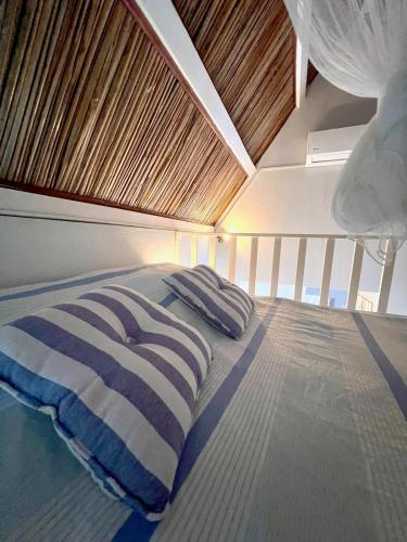 a bed in a boat with a wooden ceiling at Ti Lakaz Kreol 2 in Pereybere