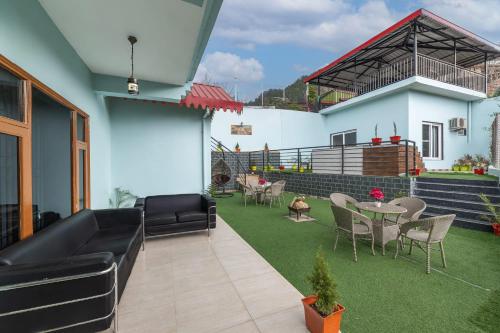 a patio with a couch and a table and chairs at Exotic Stays I Pine Group Of Hotels & Villas Kasauli in Kasauli