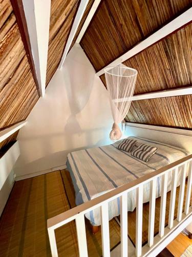 a bed in a room with a wooden ceiling at Ti Lakaz Kreol 2 in Pereybere
