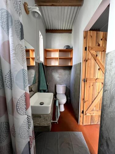 a bathroom with a sink and a toilet and a door at Ti Lakaz Kreol 2 in Pereybere