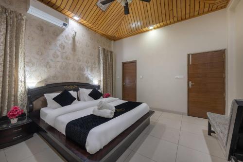 a bedroom with a large bed and a television at Exotic Stays I Pine Group Of Hotels & Villas Kasauli in Kasauli