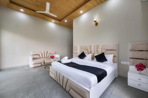 a bedroom with a large bed and a chair at Exotic Stays I Pine Group Of Hotels & Villas Kasauli in Kasauli