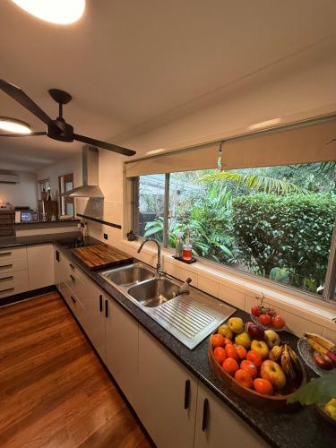 a kitchen with a sink and a large window at Boongala - Central 3BR pet friendly family home in Maroochydore