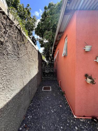 an alley with a red wall next to a building at Ti Lakaz Kreol 2 in Pereybere