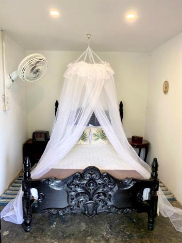 a bedroom with a bed with a mosquito net at TURULEKA Hostel in Roldanillo